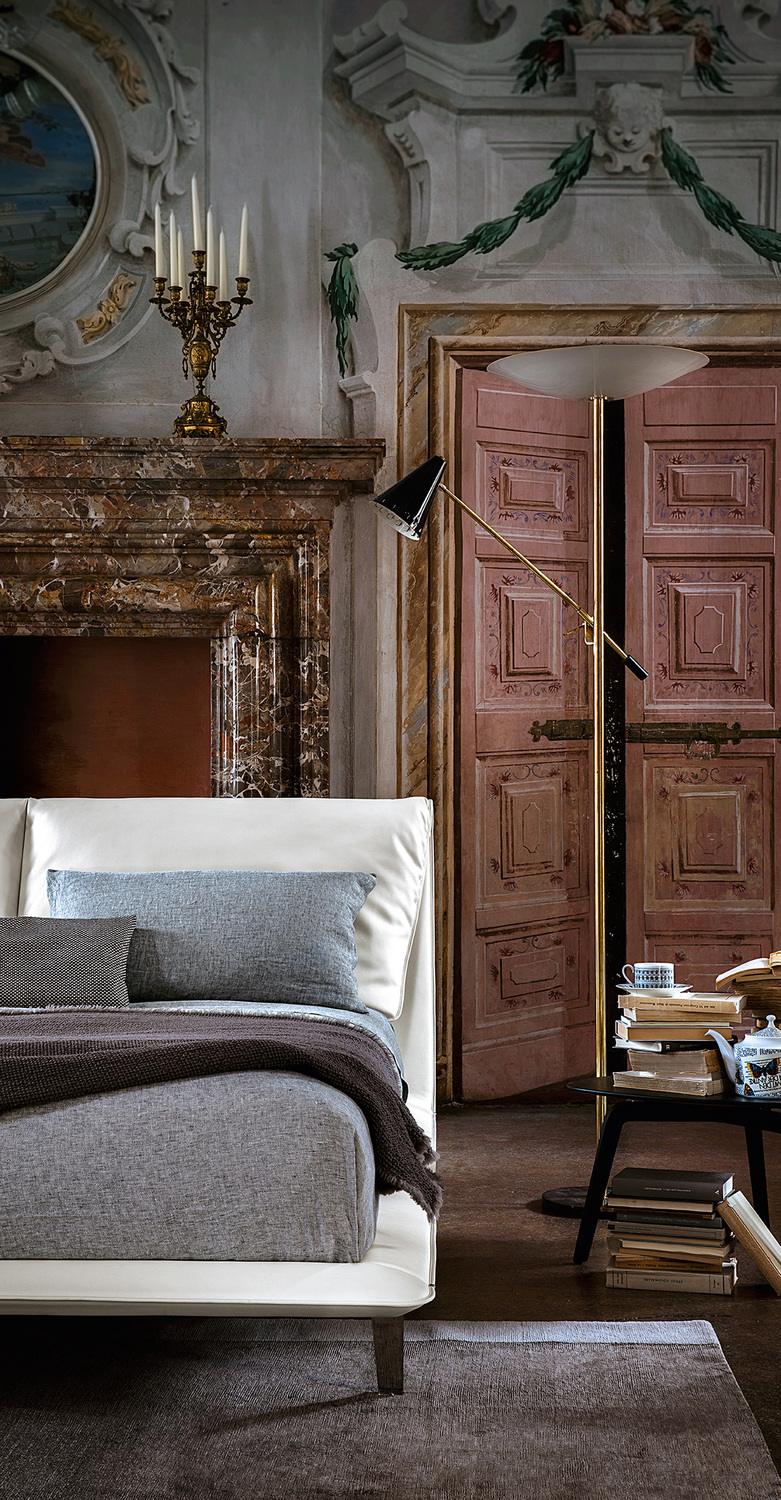 Poltrona Frau的John John床具，配有软包床头板和皮革饰面。