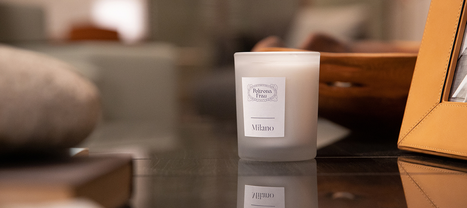 Milano | Candela Milano Candle Poltrona Frau, vetro satinato grigio con etichetta bianca, fragranza legnoso orientale con note di pelle nera, tonka e violetta, omaggio all’eleganza milanese